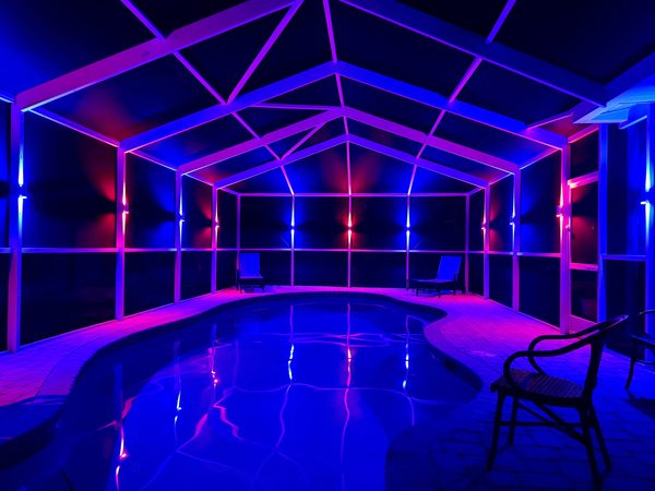Pool cage with vibrant electric blue and magenta LED color scene in Odessa