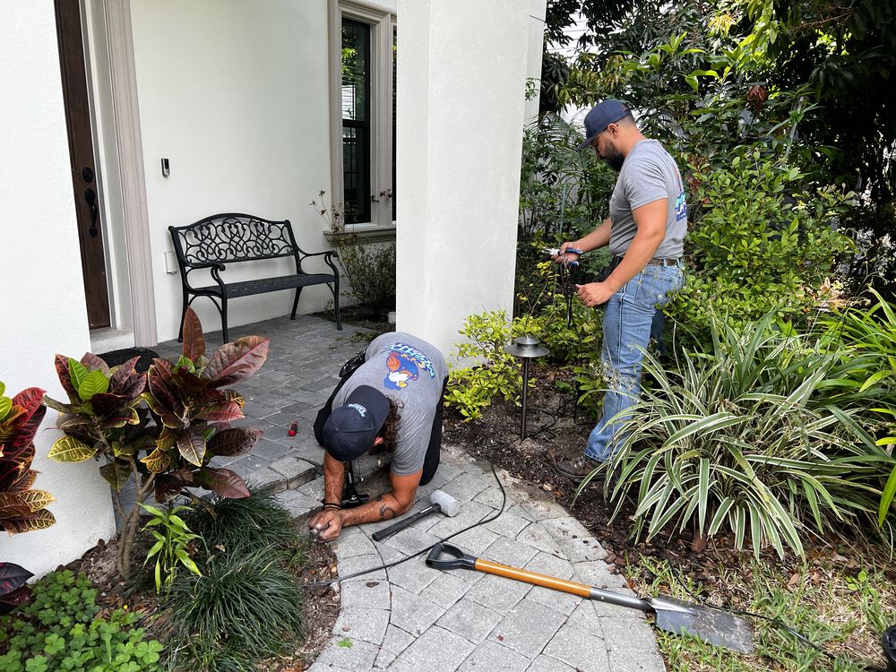 Mighty Lights technicians replacing corroded landscape lighting fixtures at a Tampa Bay home