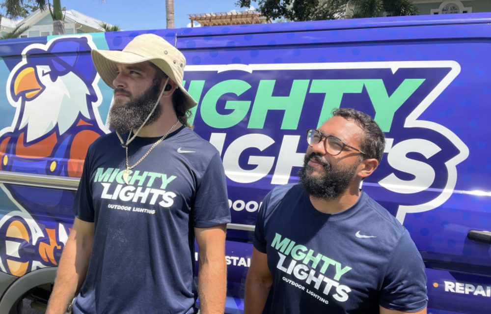 Mighty Lights Tampa Bay crew in branded shirts in front of the wrapped service van, ready to replace landscape lighting timers and photocells