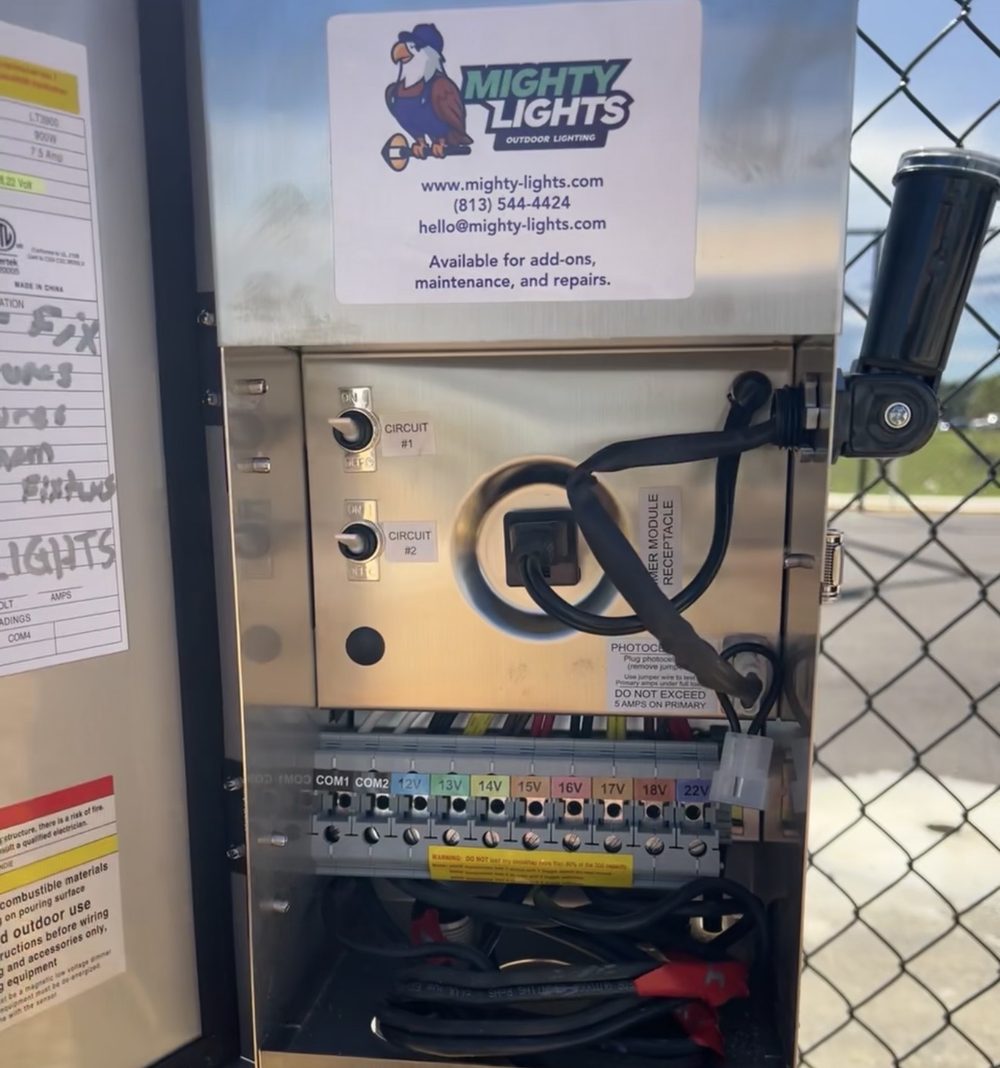 Open low-voltage landscape lighting transformer cabinet with Mighty Lights branded label and multi-circuit breaker panel for Tampa Bay repair